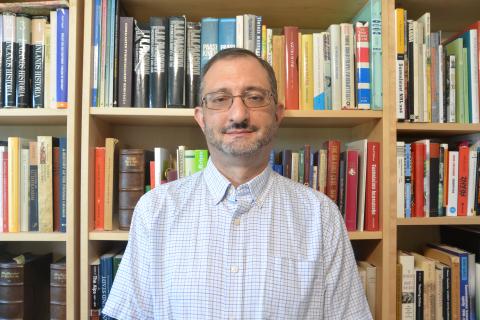 Jason Lavery Standing in Front of a Bookcase